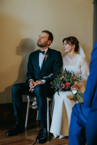 Bride and groom seated at top of alter setting