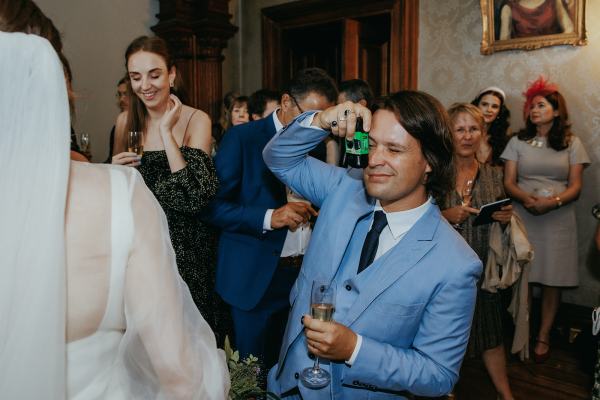 Man in blue suit takes picture on polaroid camera