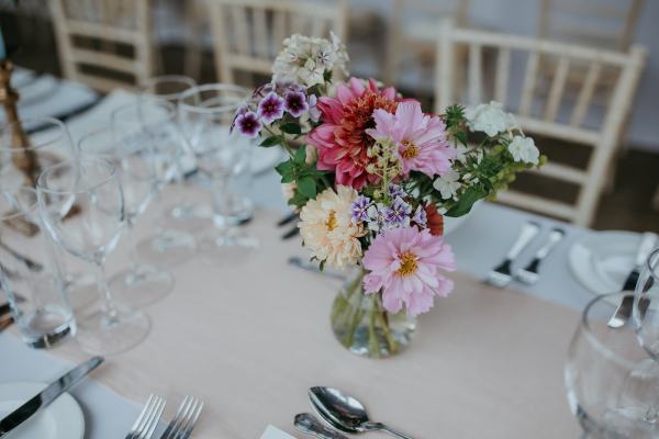 Empty dining room setting table and chairs cutlery and flowers colourful