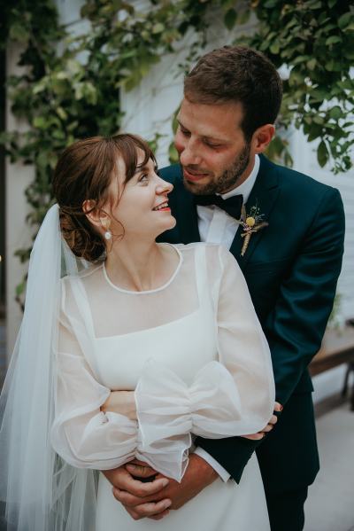 Groom looks at bride on forehead ivy in background