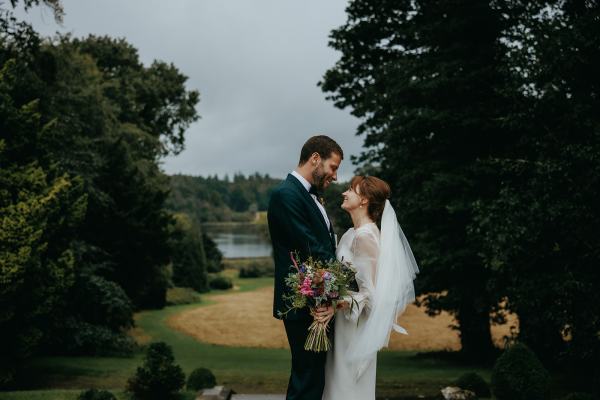 Bride and groom pose in front of landscape together