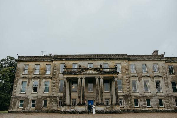 Wide shot of wedding venue bride and groom exterior pillars