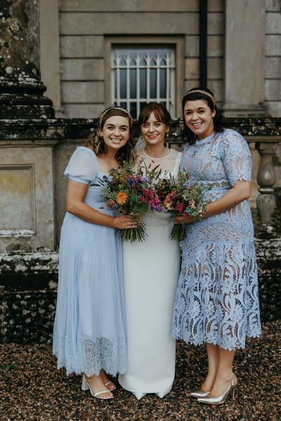 Bride and her bridesmaids pose outside