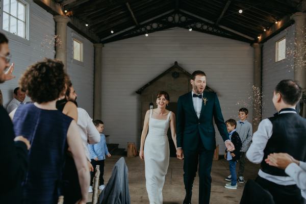 Bride and groom enter ballroom with guests clapping