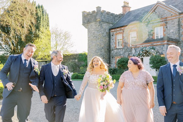 bride groom bridesmaids and groomsmen walk outside in the courtyard