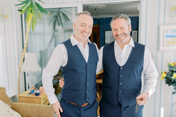 Groom and groomsman pose smiling