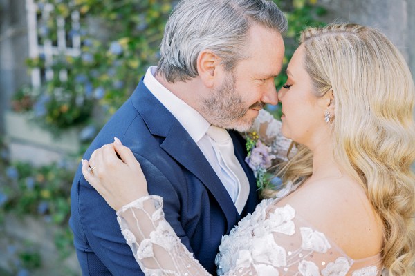 Bride and groom go in for a kiss outside in garden