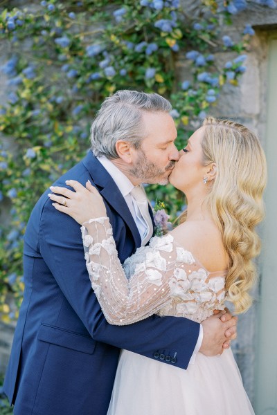 Bride and groom kiss outside in garden