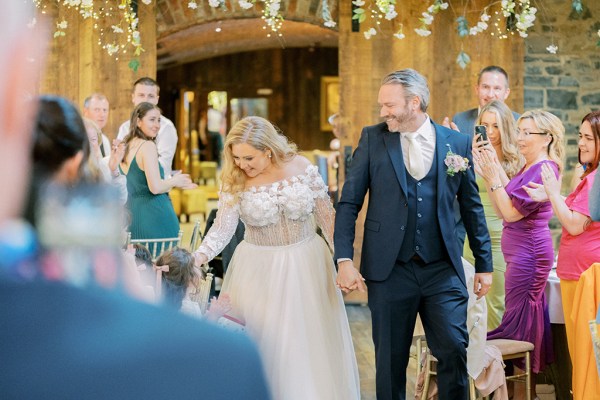 Bride and groom interior dining room shot guests clap