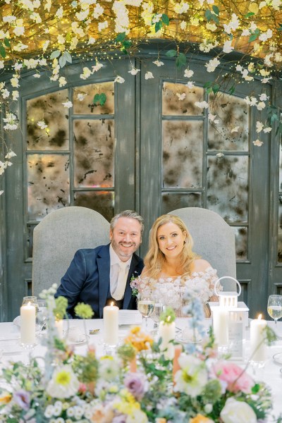 Bride and groom pose smile at the table