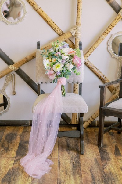 Pink bouquet flowers roses and material lying on chair