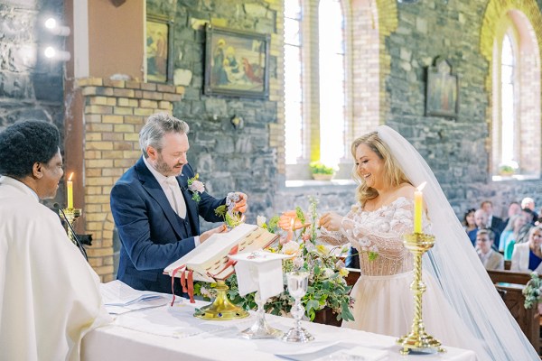 Bride and groom lighting candles at the alter