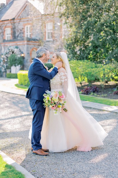 Groom puts hand on brides neck as they hold each other