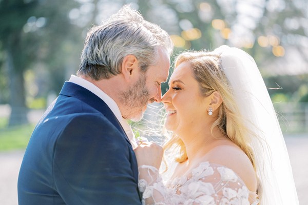 Bride and groom smile noses touching