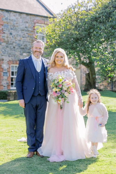 Bride groom and daughter little girl smile for the camera