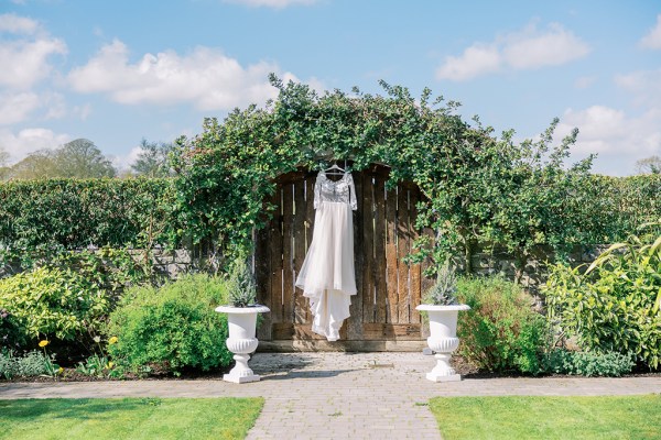 Bridal gown dress hanging up in garden