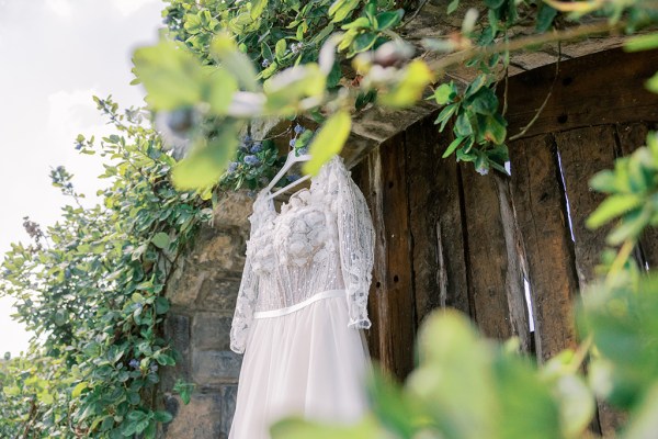 Lace bridal gown/dress hangs up in garden