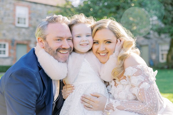 Bride groom and daughter smiling