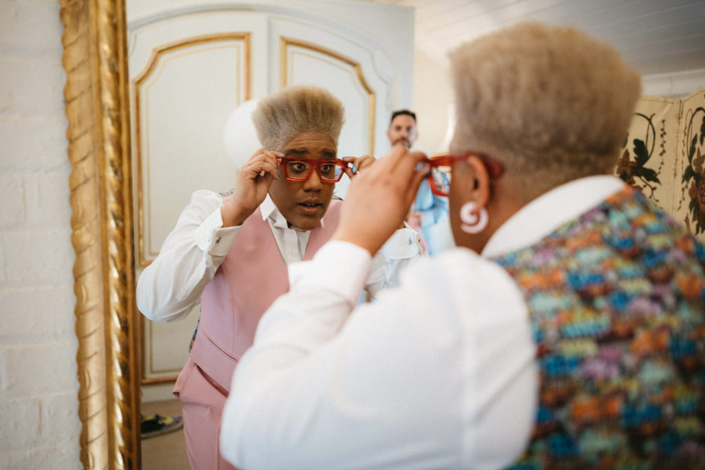 Bride looks at her reflection in mirror as she gets ready