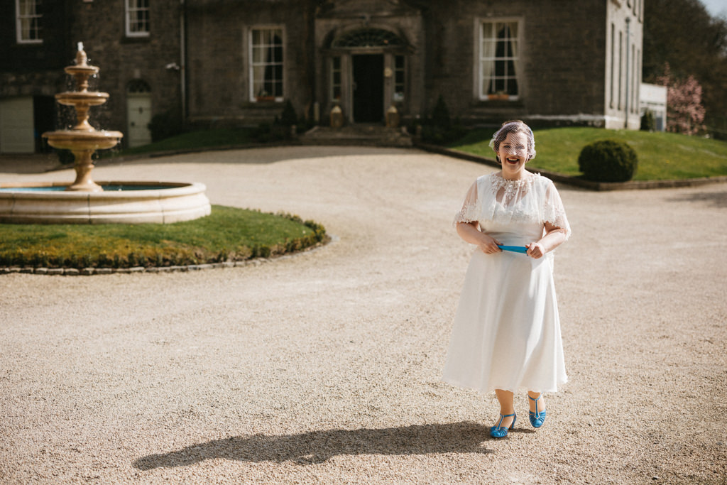 Bride stands in front of fountain smiling