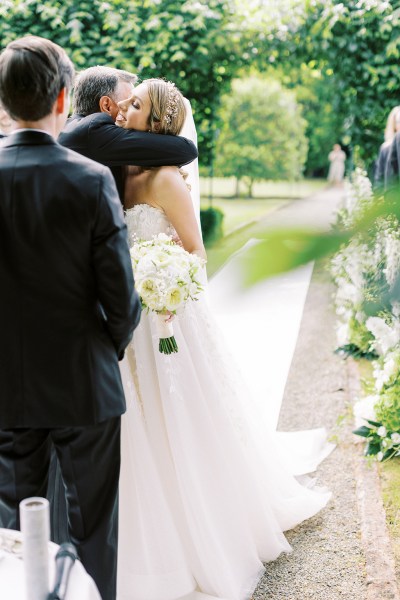 Father of the bride hugs his daughter at alter