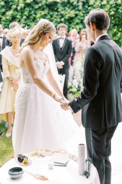 Bride and groom hold hands at the alter