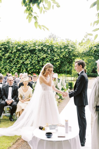 Emotional bride starts to cry at alter with groom they hold hands