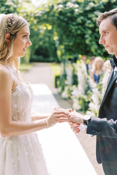 Bride and groom hold hands at the top of alter