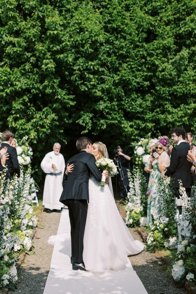 Bride and groom hugging at alter in front of guests