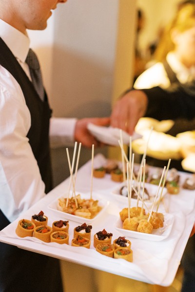 Waiter serving finger food on sticks