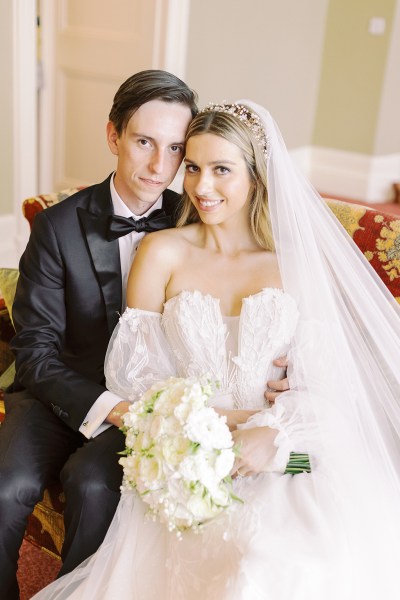 Bride and groom embrace hold each other while facing the camera