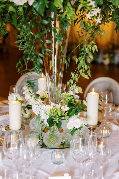 Candles lit on table ivy and flowers