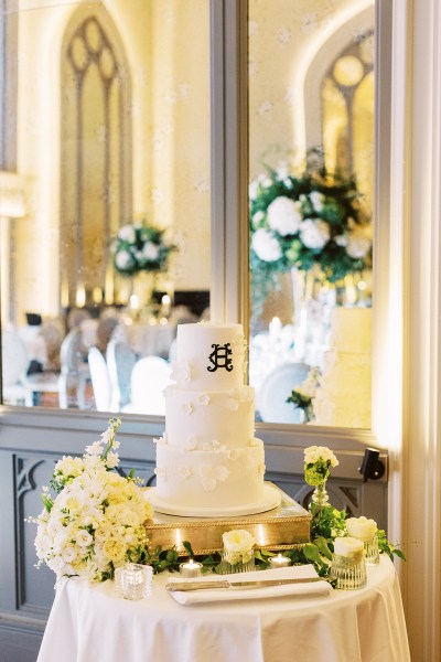 Wedding cake resting on table with candles lit