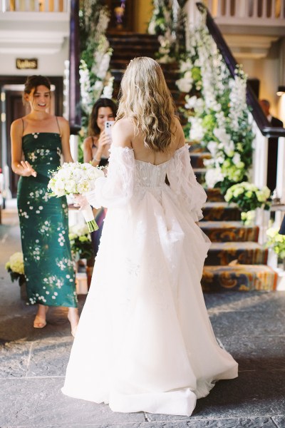 Back of brides dress being greeted by mother