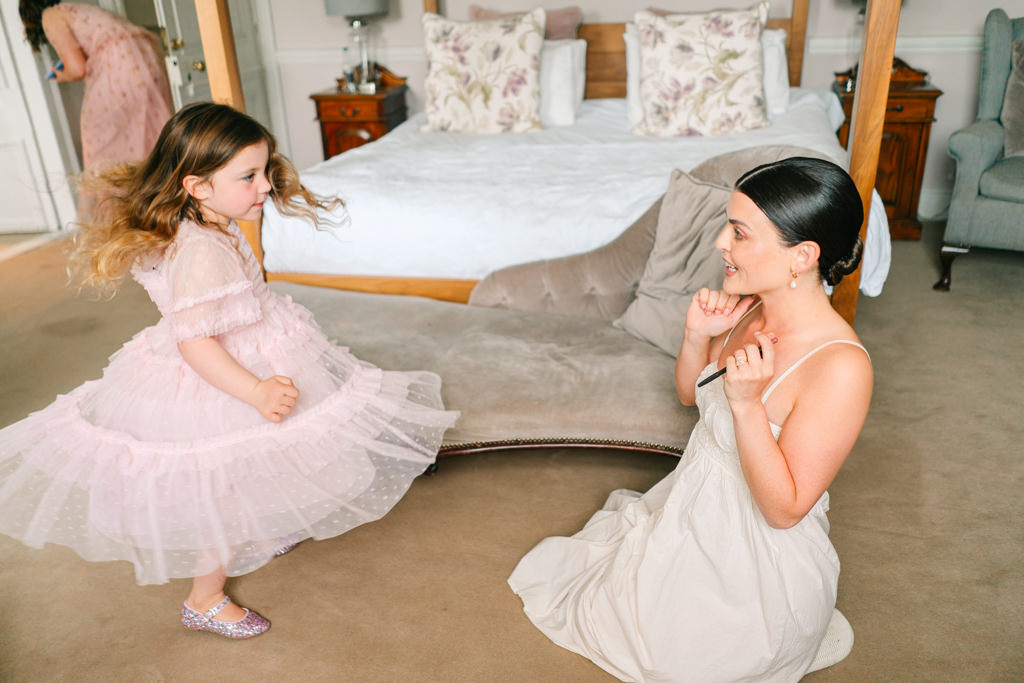 Bride and little girl showing off dress