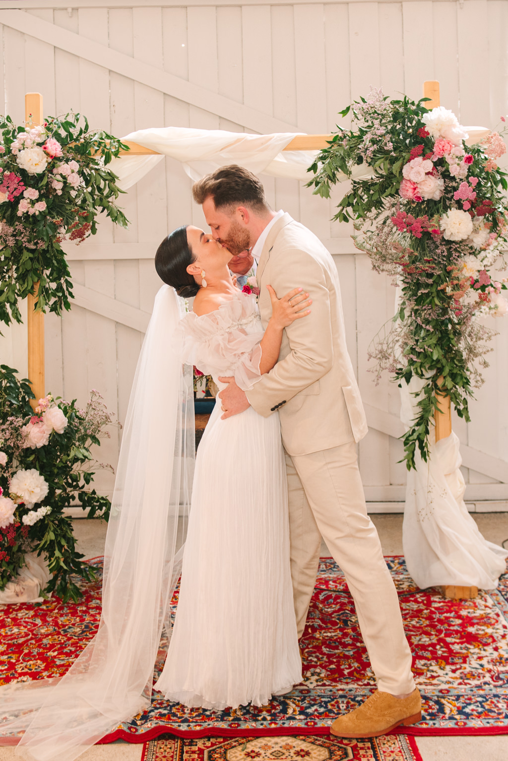 Bride and groom lean in for a kiss during ceremony