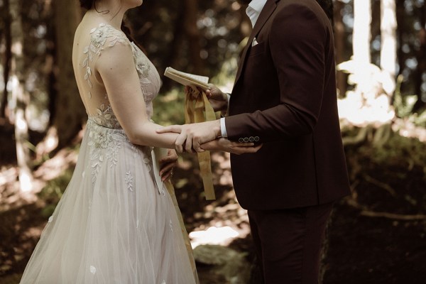 Bride and groom cup arms hands as they stand together