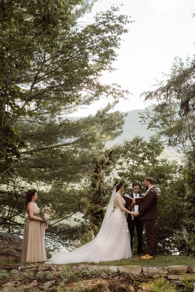 Bride and groom at the alter in front of guests in forest setting