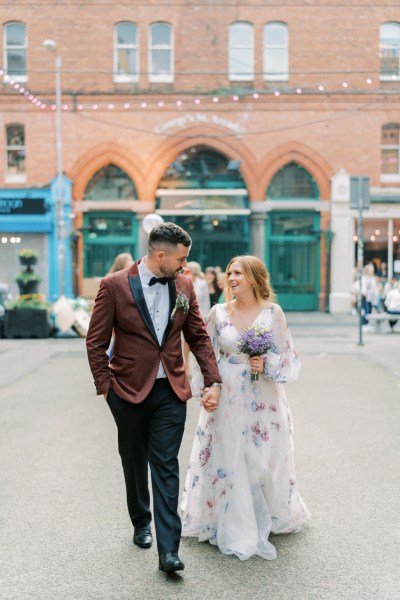 Bride and groom walking in courtyard / street