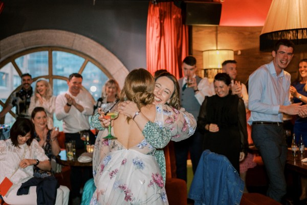 Bride hugging friend guest