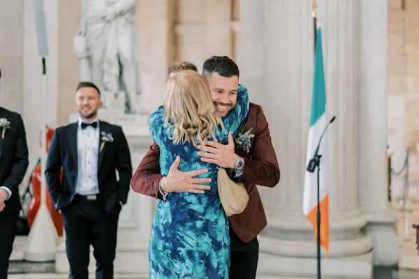 Groom hugging woman/mother in blue dress