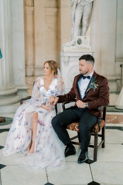 Bride and groom sitting during ceremony interior church