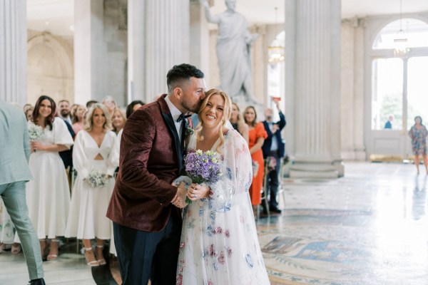 Groom kisses bride on top of head ceremony