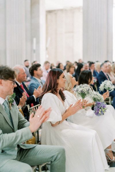 Guests clapping in audience crowd bridesmaids and groomsmen