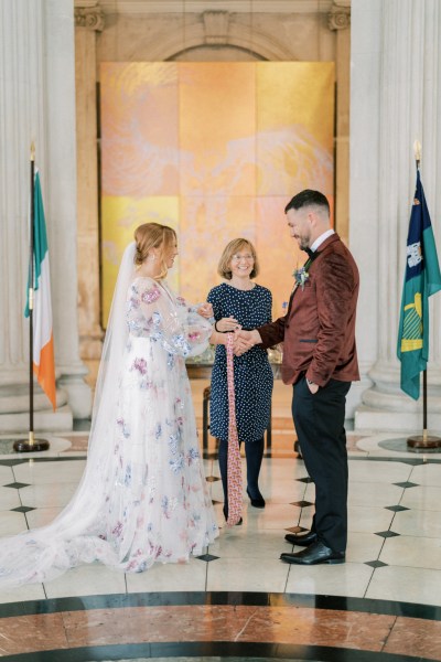 Bride and groom standing in front of celebrant at alter