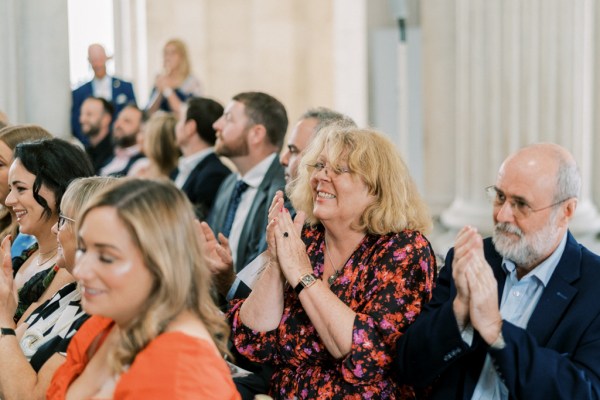 Guests clapping smiling in audience during ceremony