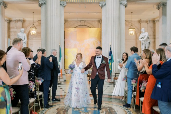 Bride and groom exit ceremony holding hands guests clapping