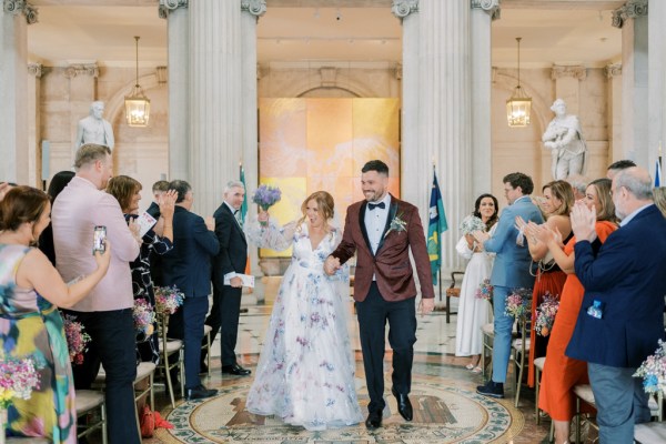 Bride and groom exit ceremony holding hands guests clapping