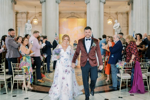 Bride and groom exit ceremony holding hands guests clapping