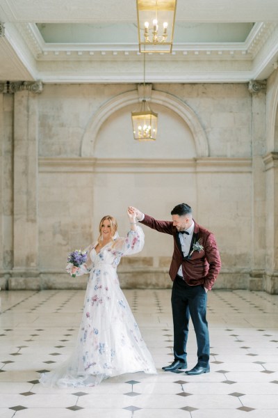 Bride and groom dance on the white and black tiles interior